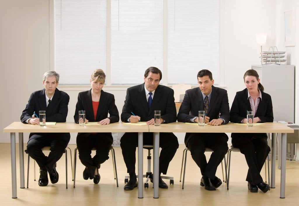 Panel of co-workers about to conduct a job interview