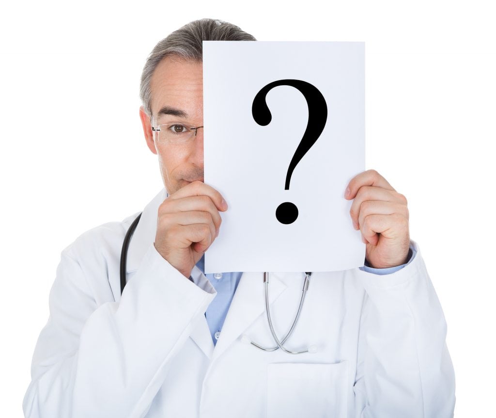 Portrait of doctor holding paper with question mark isolated on white background