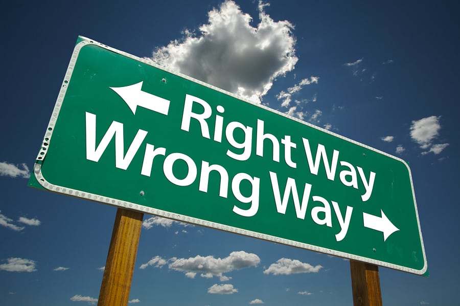 "Right Way, Wrong Way" Road Sign with dramatic blue sky and clouds.